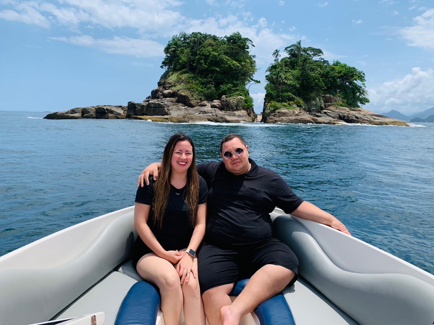 Casal na lancha em frente à Ilha Rachada